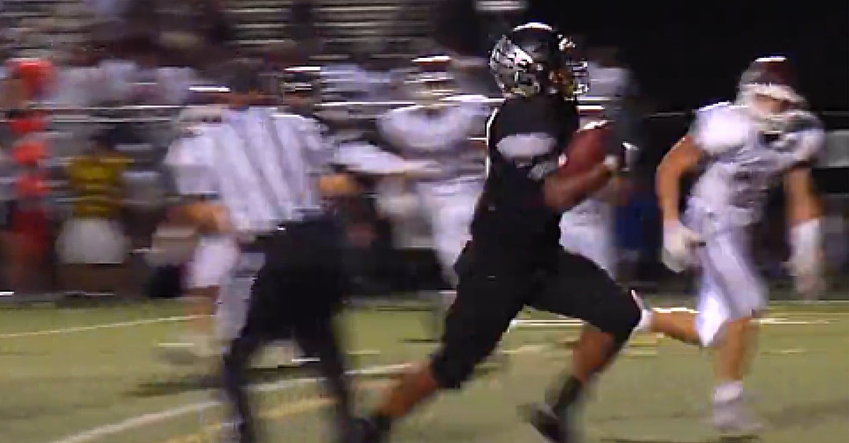 A football player running with the ball in his hands.