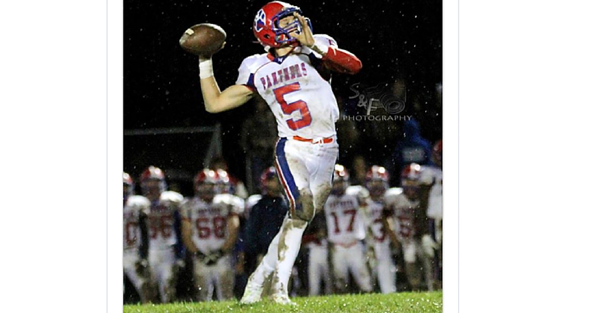 A football player is throwing the ball to his teammates.