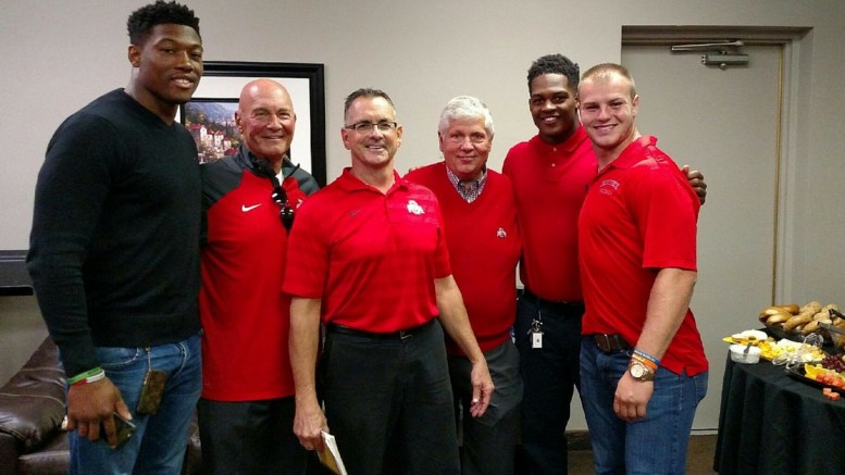 A group of men in red shirts standing next to each other.