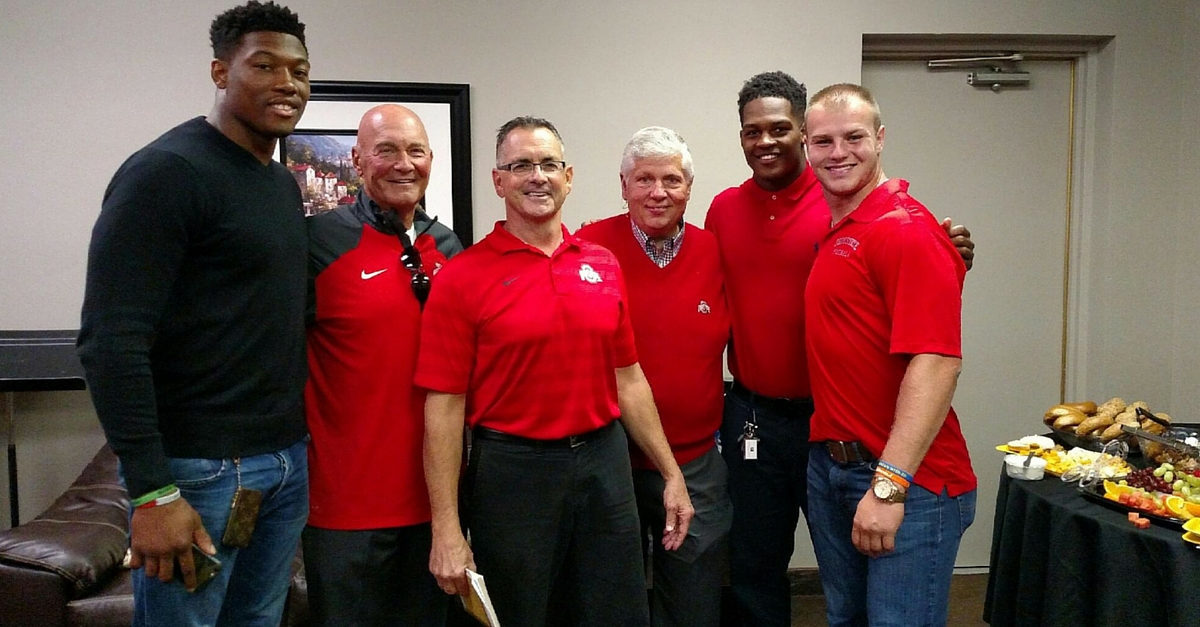 A group of men in red shirts standing next to each other.