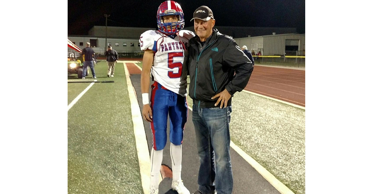 A man and a football player posing for the camera.