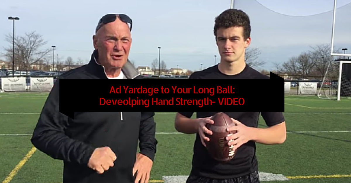 A man and boy holding a football on top of a field.