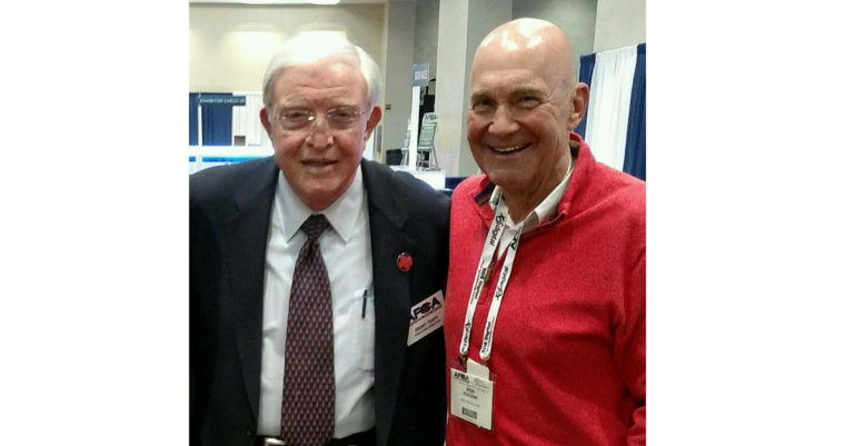 Two men standing next to each other in a room.