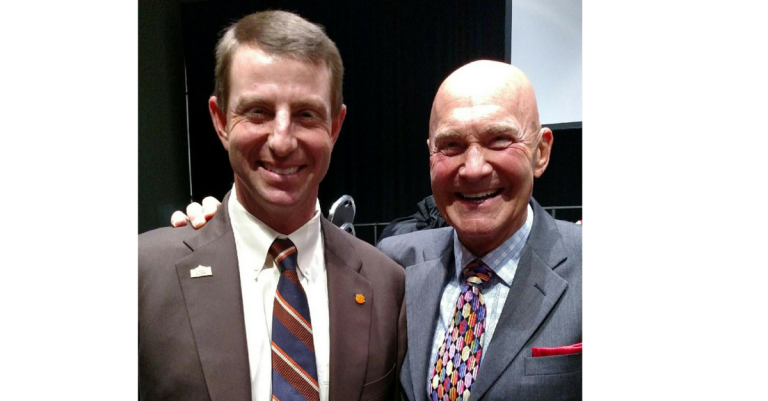 Two men in suits and ties posing for a picture.