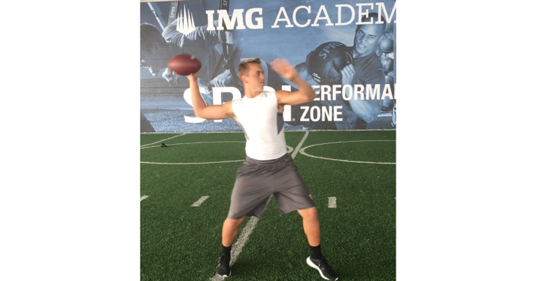 A man holding a football on top of a field.