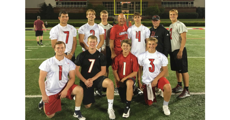 A group of men in football uniforms posing for a picture.