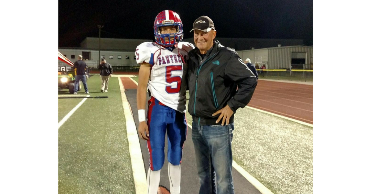 A man and a boy standing on top of a field.