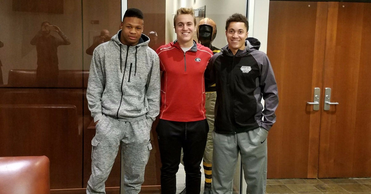 Three young men standing next to each other.