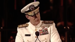 A man in military uniform is speaking at a podium.