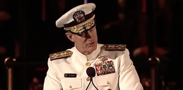 A man in military uniform is speaking at a podium.