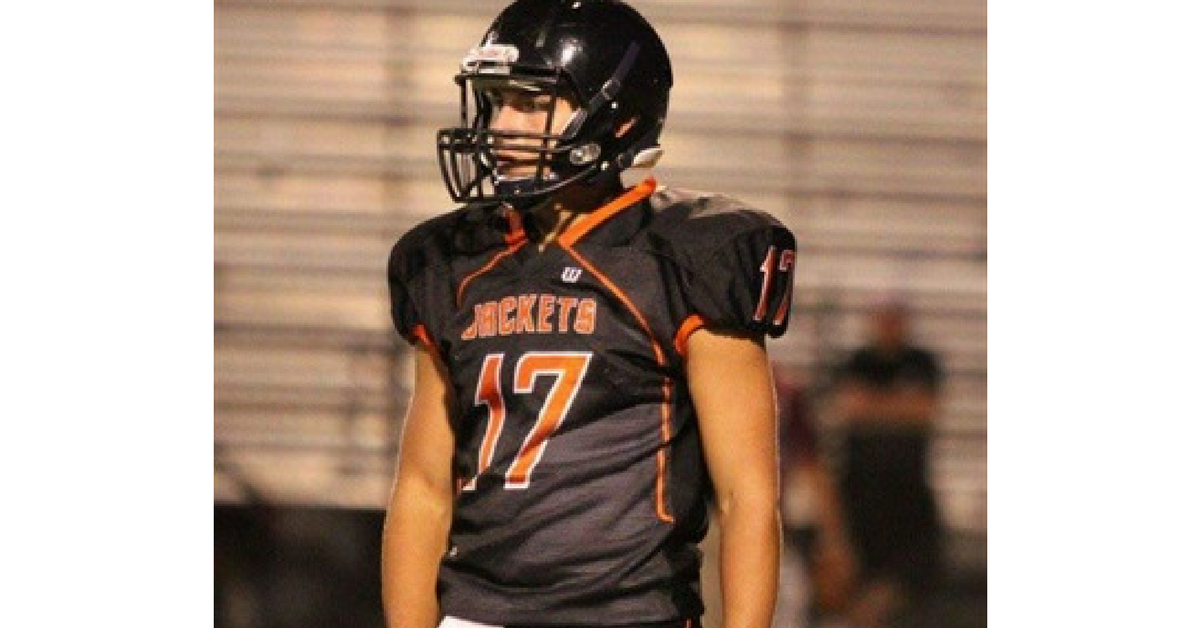 A football player in uniform with his helmet on.