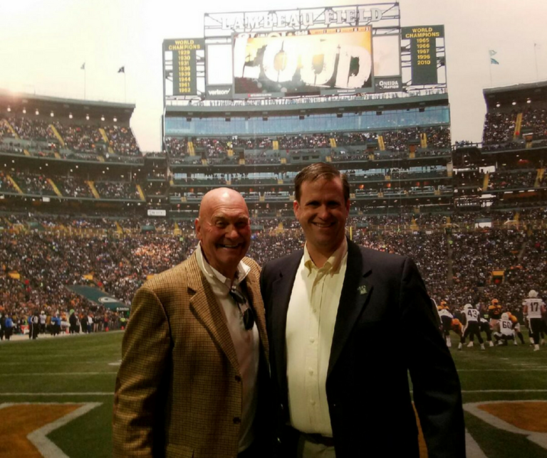 Two men standing in front of a stadium.