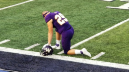 A football player kneeling down on the field