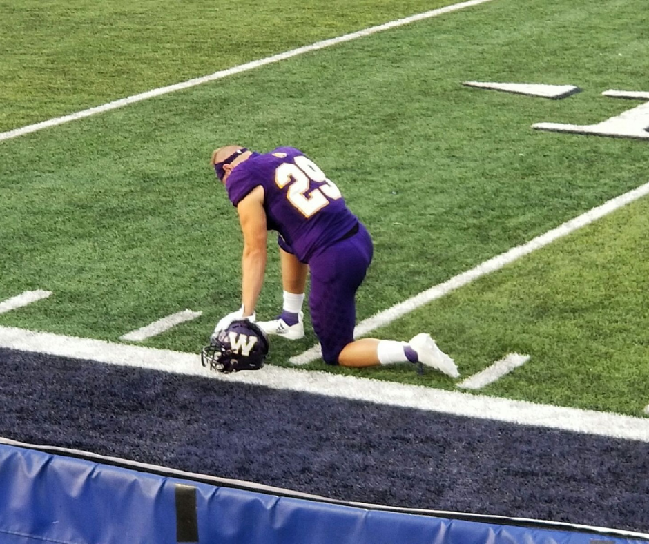 A football player kneeling down on the field