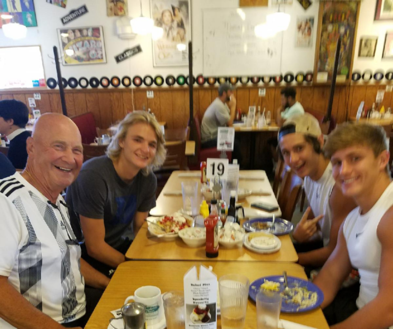 A group of people sitting at a table with food.