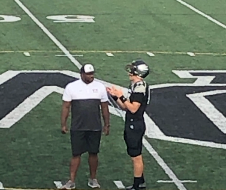 A football player talking to an official on the field.