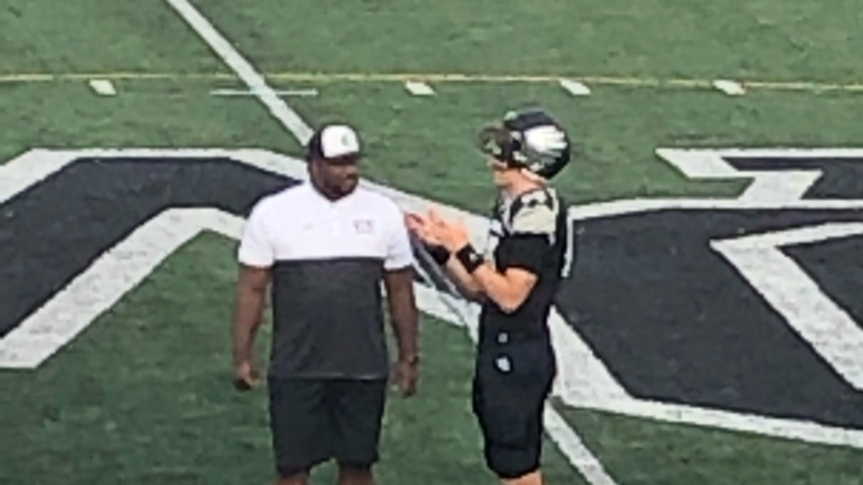 A football player talking to an official on the field.