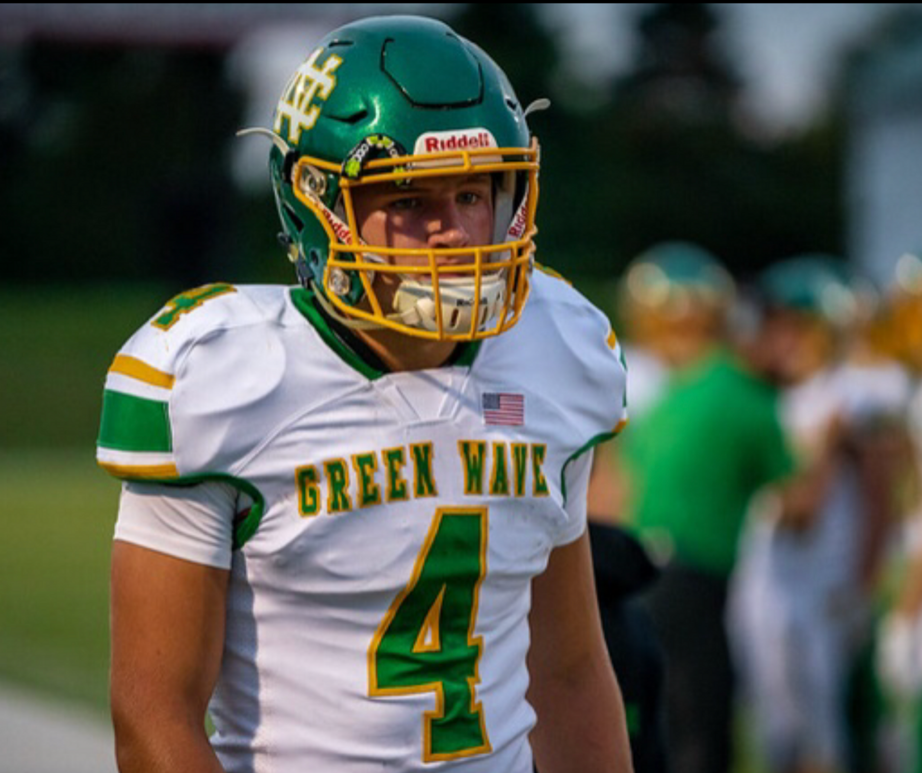 A football player in uniform is standing on the field.