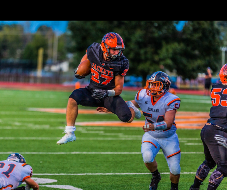 A football player jumping in the air to catch a ball