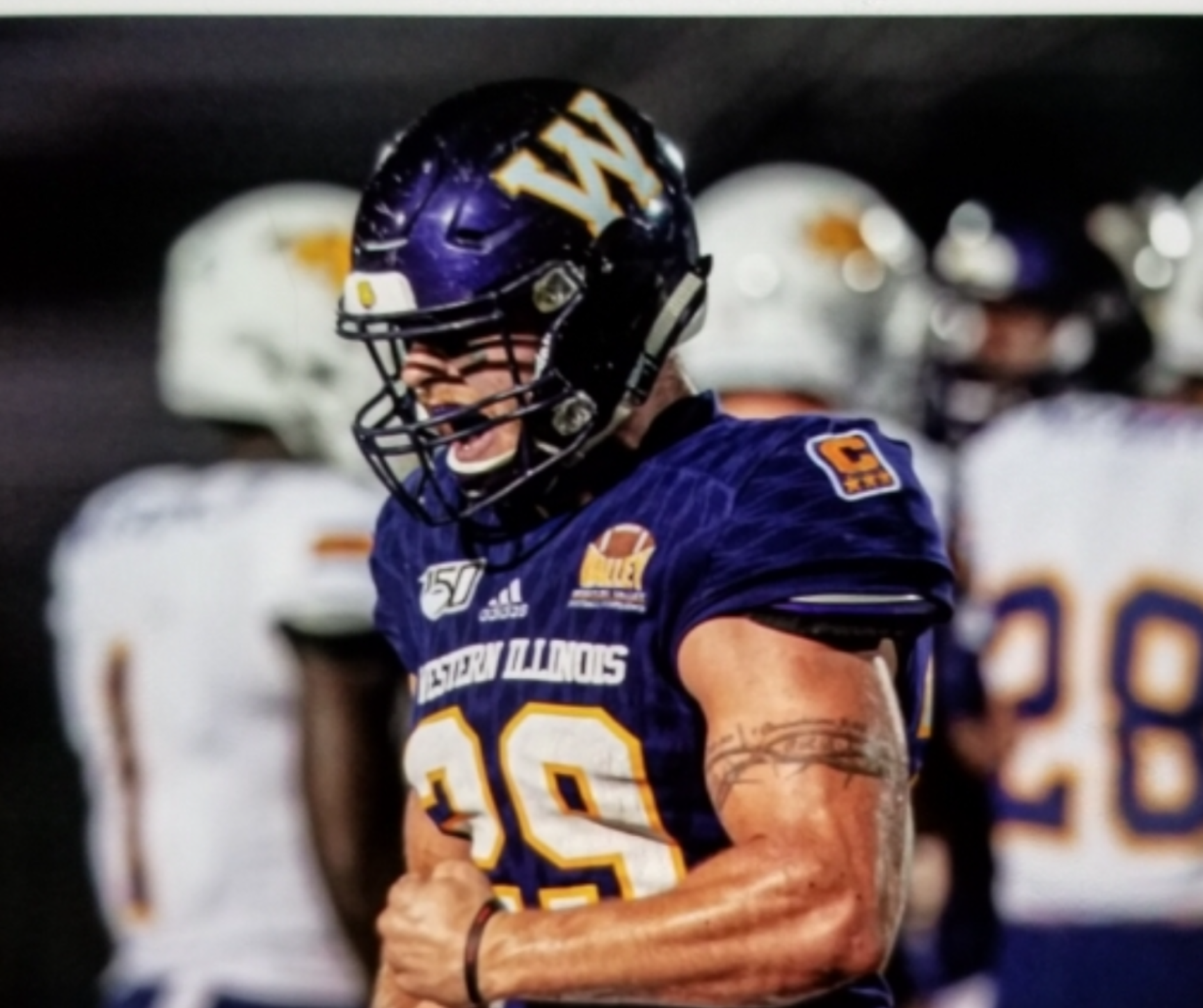 A football player in purple and white uniform.