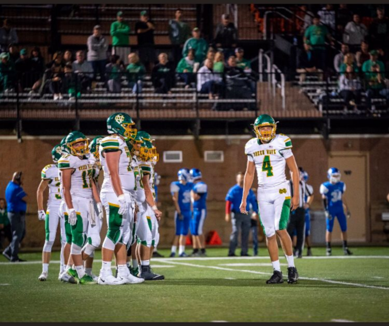 A group of football players standing on top of a field.